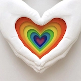 Pride artwork of two hands enclosing a rainbow-colored heart.