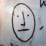 Spray-painted face on a wall.