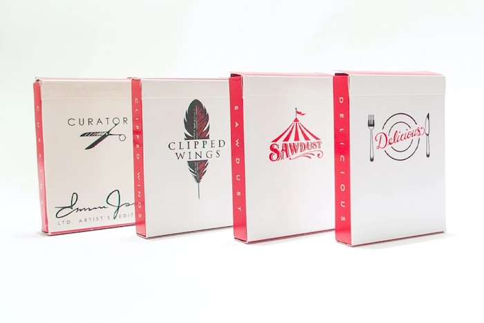 Four decks of custom playing cards, standing upright against a white background.